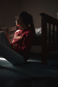 A photo of a woman sitting on the floor, looking overwhelmed.