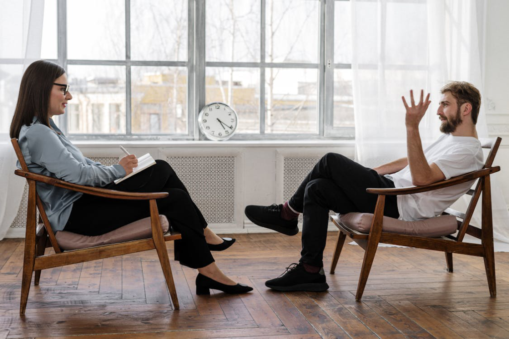 A woman taking notes while listening to a man sharing his thoughts