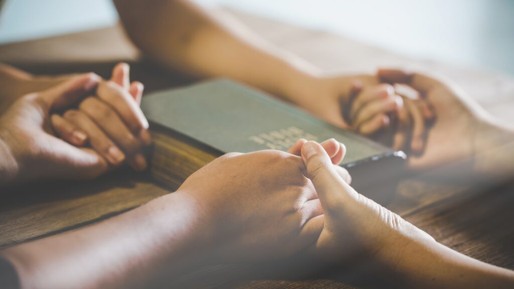 holding hands over bible